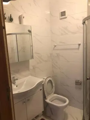 a white bathroom with a toilet and a sink at appartement center de Guéliz avec piscine in Marrakech