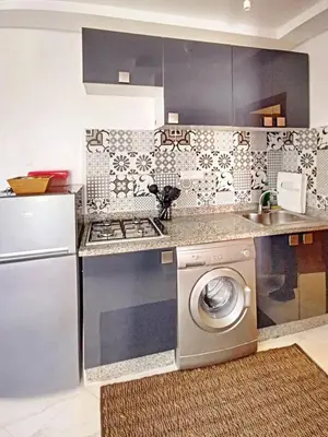 a kitchen with a stove and a washing machine at appartement center de Guéliz avec piscine in Marrakech