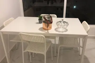 a white table with chairs and a vase on it at appartement center de Guéliz avec piscine in Marrakech