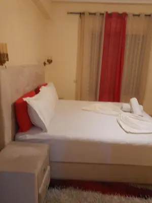 a bedroom with a white bed and a red curtain at Appartement spacieux in Marrakech
