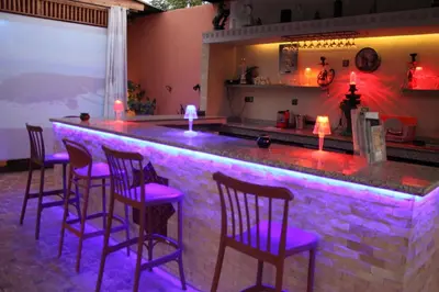 a bar with purple bar stools in front of it at Villa Gardens Diafa in Marrakech