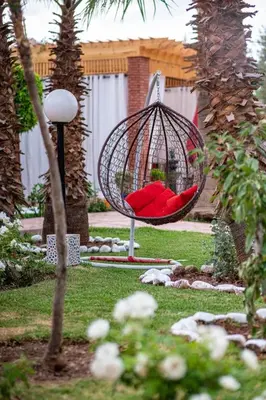 a swing with a red seat in a yard at Villa Gardens Diafa in Marrakech