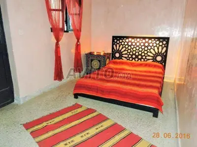 a bedroom with a bed with an orange and red blanket at appartement Bahia jame el fna in Marrakech