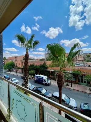 a view of a parking lot with palm trees from a balcony at Golden house in Marrakech
