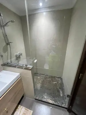a shower with a glass door next to a sink at Golden house in Marrakech