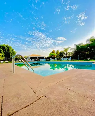 a swimming pool with a metal hand rail next to it at Villa Baddi Marrakech in Marrakech