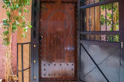a wooden door with a gate in front of a building at Riad Amely in Marrakech