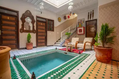 a swimming pool in a living room with a house at Riad HAFSSA & Spa in Marrakech