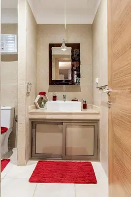 a bathroom with a white sink and a red rug at Magnifique Appartement lux - Perles de Coralia in Marrakech
