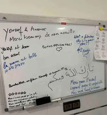 a whiteboard with writing on it in a room at Jardin Majorelle Cozy Apartment in Marrakech