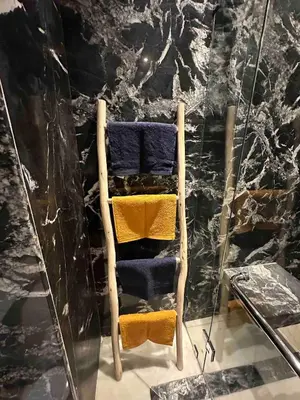 a wooden chair with towels on it in a room at Jardin Majorelle Cozy Apartment in Marrakech