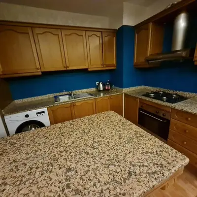 a kitchen with wooden cabinets and a counter top at Appartement cosy quartier au centre de Marrakech Gueliz in Marrakech