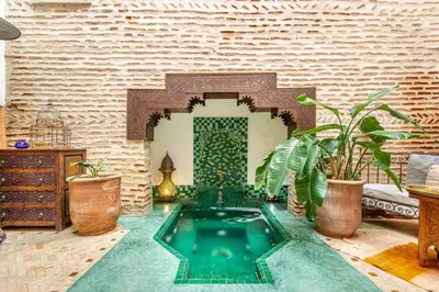 a swimming pool in the middle of a room with plants at Riad El Faris Exclusif-Included Moroccan Breakfast in Marrakech