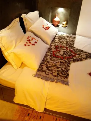 a bed with white pillows and a blanket on it at Riad of The Light in Marrakech