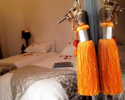 a bedroom with two beds with tassels on the wall at Riad of The Light in Marrakech