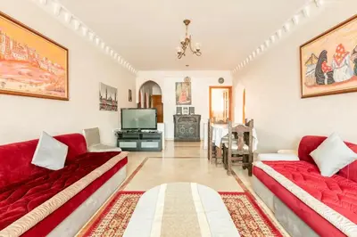a living room with two red couches and a television at Appartement spacieux Centre Marrakech in Marrakech