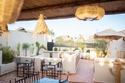 a patio with tables and chairs and an umbrella at Riad IMPERIA in Marrakech