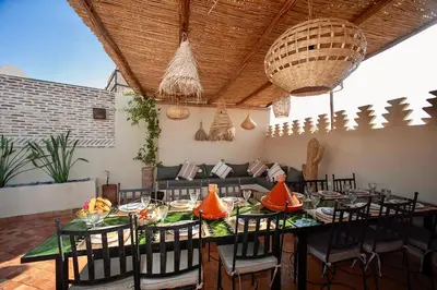 a dining room with a long table and chairs at Riad IMPERIA in Marrakech