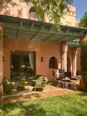 a patio with chairs and a table on a house at Palmeraie Village 2 - Cosi appartement en Rez de Jardin in Marrakech