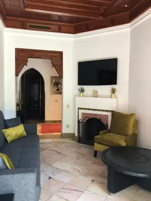 a living room with a couch and a fireplace at Palmeraie Village 2 - Cosi appartement en Rez de Jardin in Marrakech