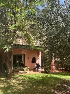 a house with a patio and a yard with trees at Palmeraie Village 2 - Cosi appartement en Rez de Jardin in Marrakech