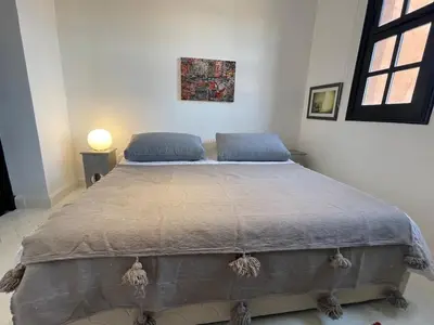 a bedroom with a large bed with blue pillows at La Villa 2A, Palmeraie, Marrakech in Marrakech