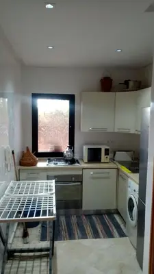 a small kitchen with a stove and a window at appartment avec piscine in Marrakech