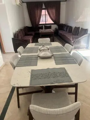 a table in a room with chairs and a couch at appartment avec piscine in Marrakech