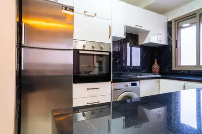 a kitchen with a refrigerator and a dishwasher at L'horizon Aéroport Appartement in Marrakech
