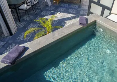a swimming pool with two towels and a table and chairs at Riad AJI 4 Rooms, Pool, Internet, Top Emplacement Médina in Marrakech