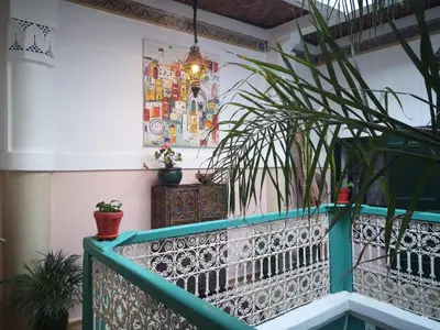 a balcony with potted plants and a chandelier at Riad El Badii chambre queen size Badii in Marrakech