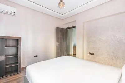 a bedroom with a large white bed and a chandelier at Modern 3-Bedroom apartment with Balcony-Central Gueliz Marrakech in Marrakech