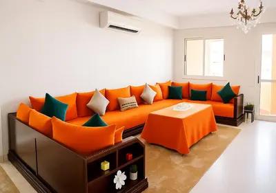 an orange couch in a living room with a table at Marrakech Appart in Marrakech