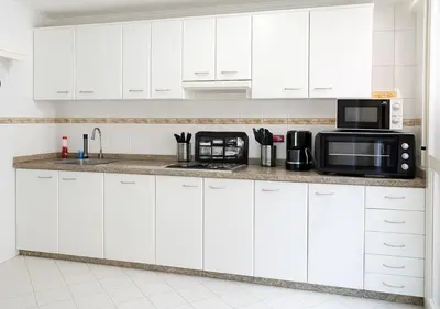 a white kitchen with white cabinets and a microwave at Marrakech Appart in Marrakech