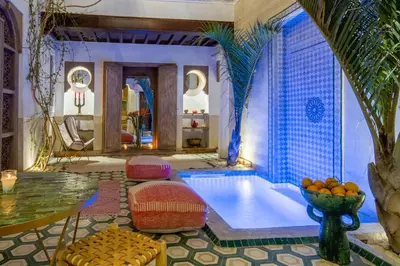 a room with a pool with a table and a bowl of oranges at Riad Bed & Breakfast Comptoir du Pacha in Marrakech