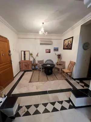 a living room with a black and white checkered floor at Superbe appartement équipé en résidence propre avec Piscine in Marrakech