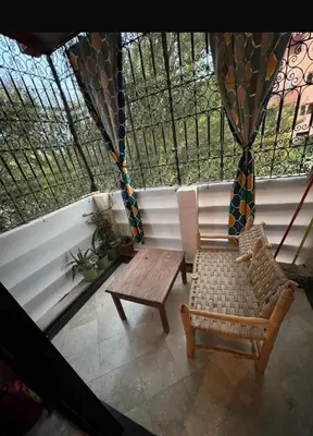 a room with a bench and a table and a window at Superbe appartement équipé en résidence propre avec Piscine in Marrakech