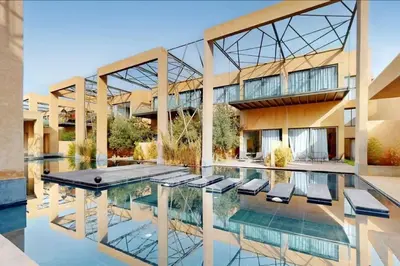 a building with a pool with chairs in front of it at Duplex Moderne 233m2 dans une magnifique résidence in Marrakech