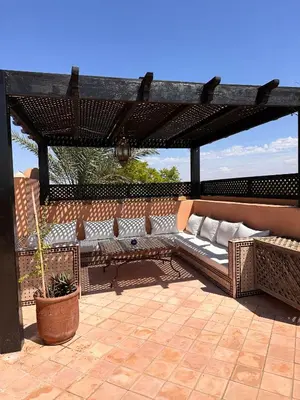 a couch under a pergola on a patio at Palm View in Marrakech