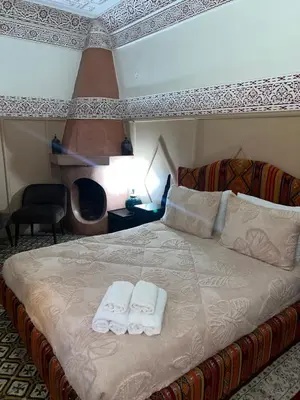 a bedroom with a bed with two towels on it at Riad La Perla Bianca in Marrakech