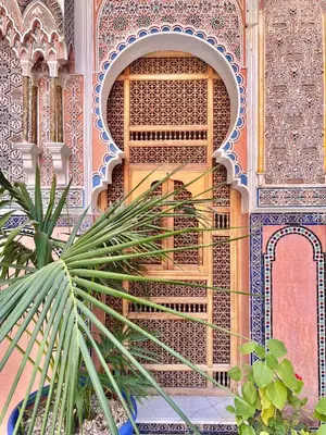a building with a palm tree in front of it at Riad Azad & Spa in Marrakech