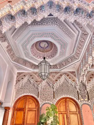 a coffered ceiling with a chandelier and wooden doors at Riad Azad & Spa in Marrakech