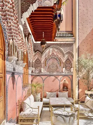 a room with a table and chairs and a wall at Riad Azad & Spa in Marrakech