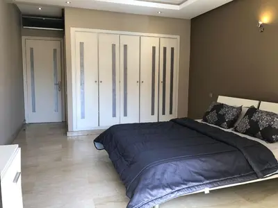 a bedroom with a large bed and a large closet at studio avec terasse carre eden iptv wifi in Marrakech