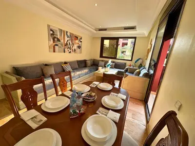 a living room with a table and a couch at Résidence Soltana, Marrakech in Marrakech