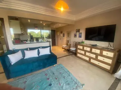 a living room with a blue couch and a flat screen tv at Superbe pied à terre sur Majorelle in Marrakech
