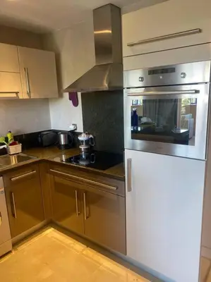 a kitchen with stainless steel appliances and wooden cabinets at Superbe pied à terre sur Majorelle in Marrakech