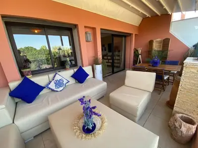 a living room with a white couch and blue pillows at Superbe pied à terre sur Majorelle in Marrakech