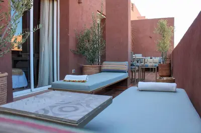 two beds on a balcony with a table and chairs at SUBLIME APPARTEMENT 2 CHAMBRES AU COEUR DE GUELIZ in Marrakech