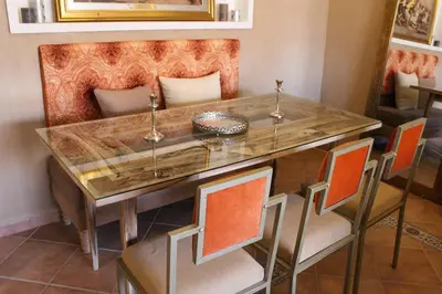 a dining room table with orange chairs and a wooden table at SUBLIME APPARTEMENT 2 CHAMBRES AU COEUR DE GUELIZ in Marrakech